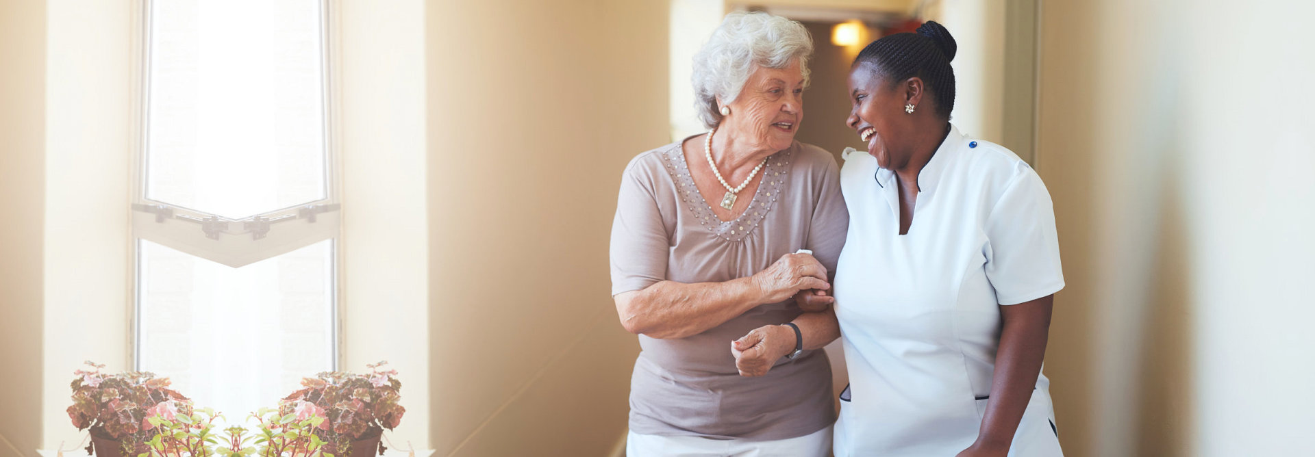 caregiver and old woman happily walking in the aisle